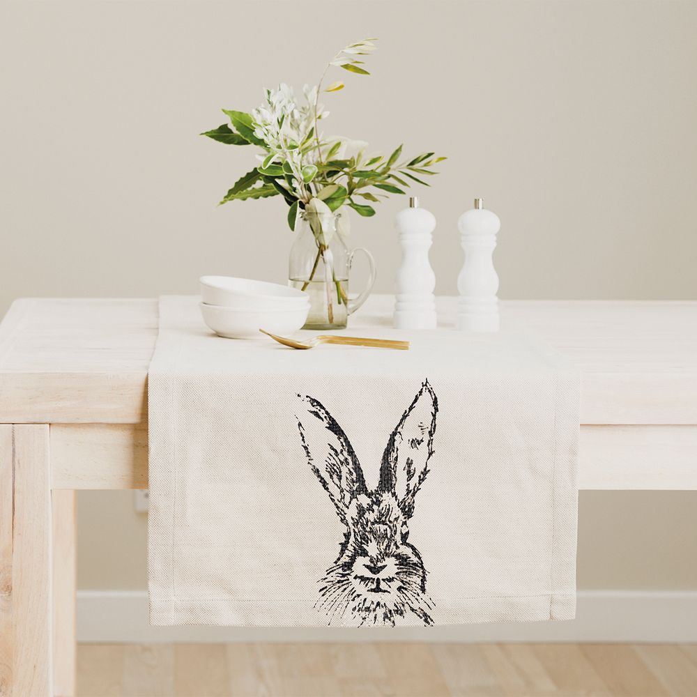 off white cream line table runner with black rabbit hare illustrated drawing on a neutral table with leaves in a vase and salt and pepper mills