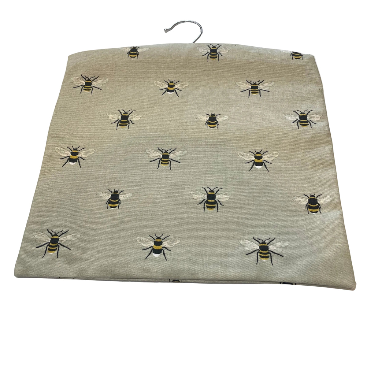 A fabric peg bag with all over bee design on a beige background with wooden coat hanger.
