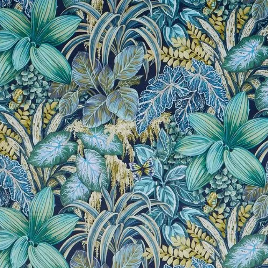 A dense tropical botanical pattern featuring large teal and blue-green leaves, smaller blue and green foliage, and yellow-green accents on a dark navy background.